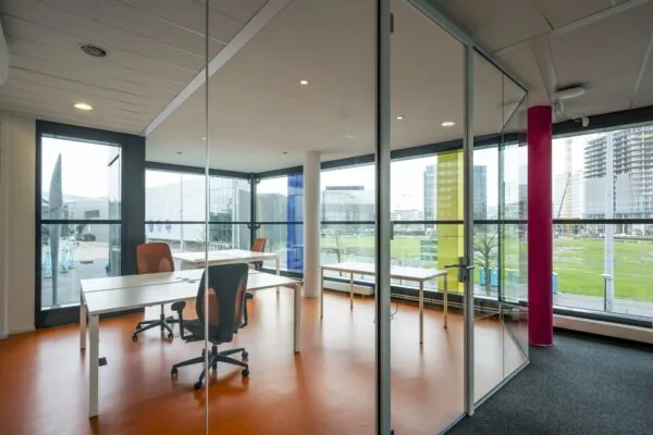 Moderne glazen kantoorruimte met uitzicht op de Johan Cruijff Boulevard in Amsterdam.